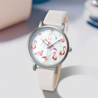 Watch with flamingo design on the dial and beige strap on a light gray background