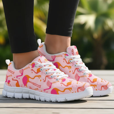 Pink sneakers with flamingo pattern worn by a person on a blurred natural background