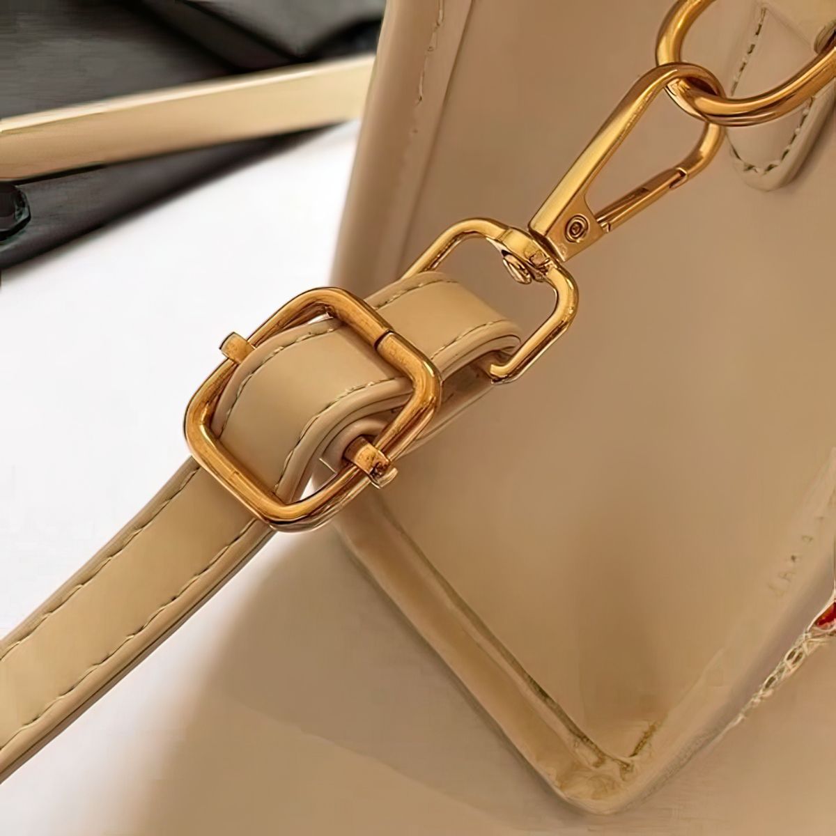 Beige handbag with gold chain strap on a light background