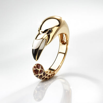 Gold flamingo-shaped ring with a detailed design on a white background