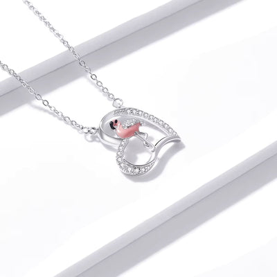 Silver necklace with a heart-shaped pendant on a white background