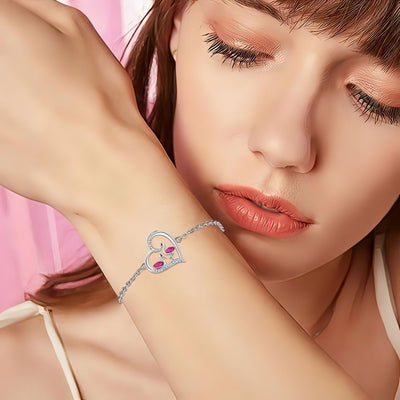 Woman wearing a flamingo bracelet with a heart design on a pink background