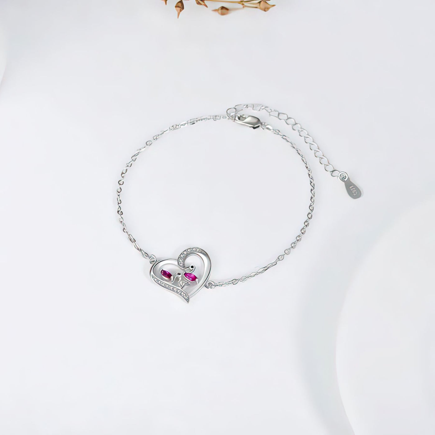 Silver flamingo bracelet with heart-shaped clasp on a white background