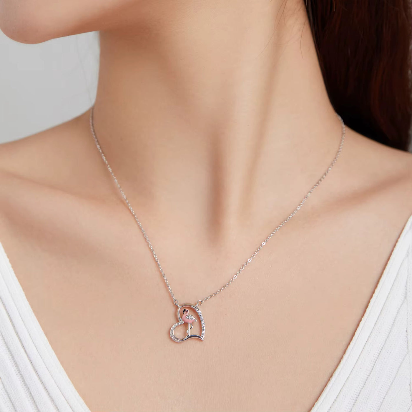 Heart-shaped necklace worn by a model on a plain background