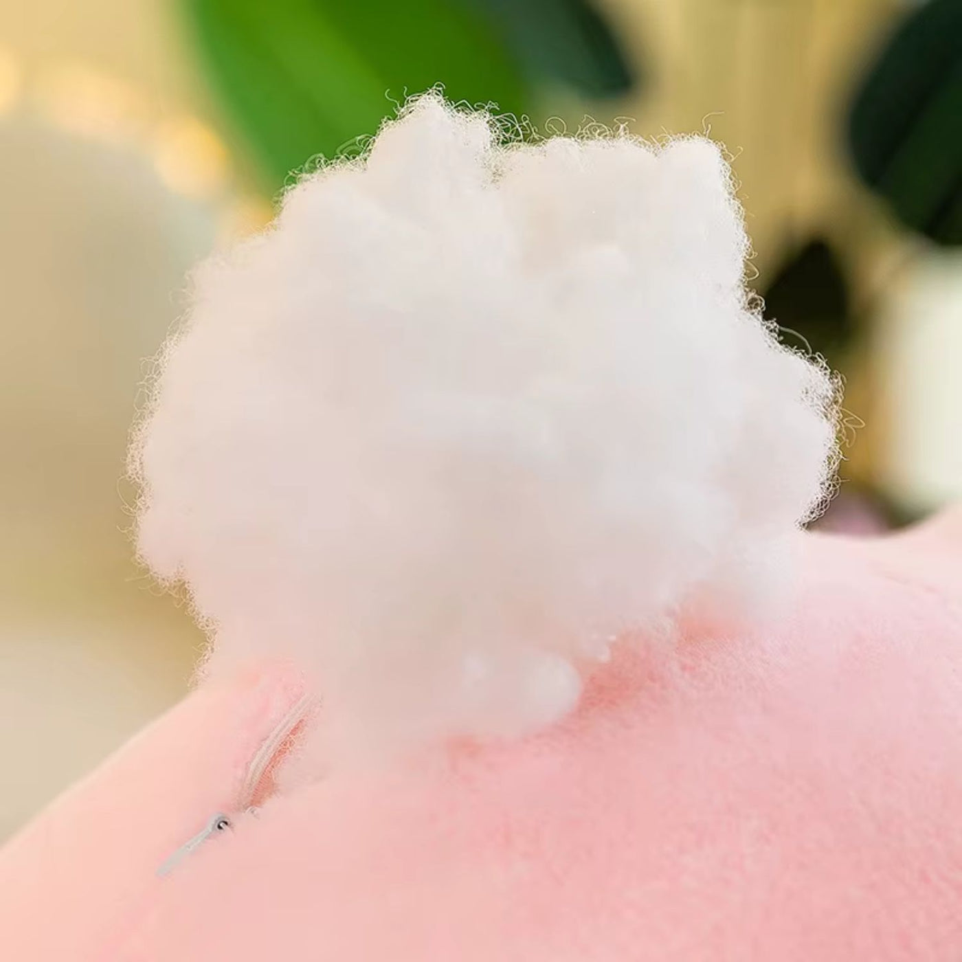 Close-up of fluffy white cotton candy held by a hand with a blurred background