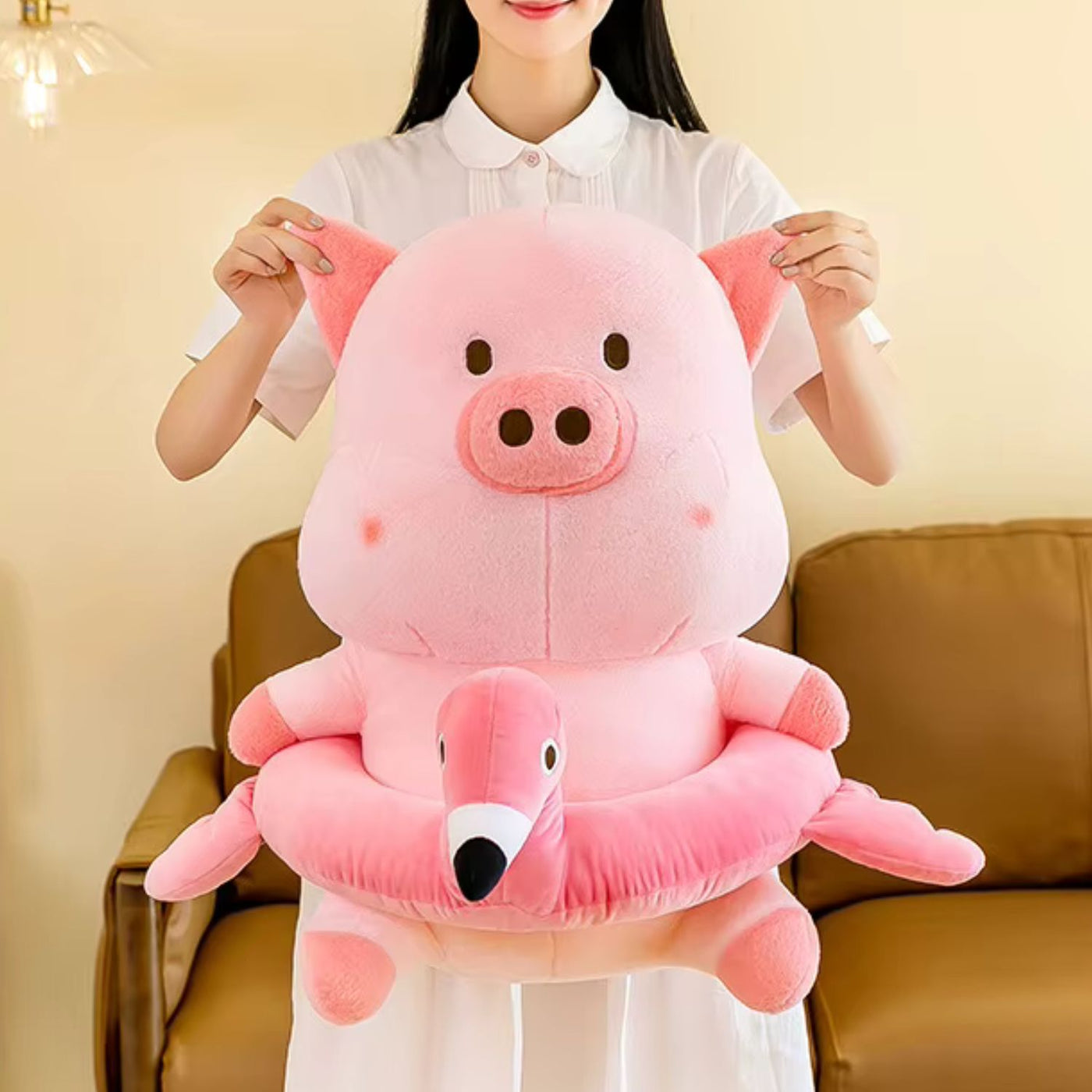Person holding a large pink plush pig toy in a living room setting.