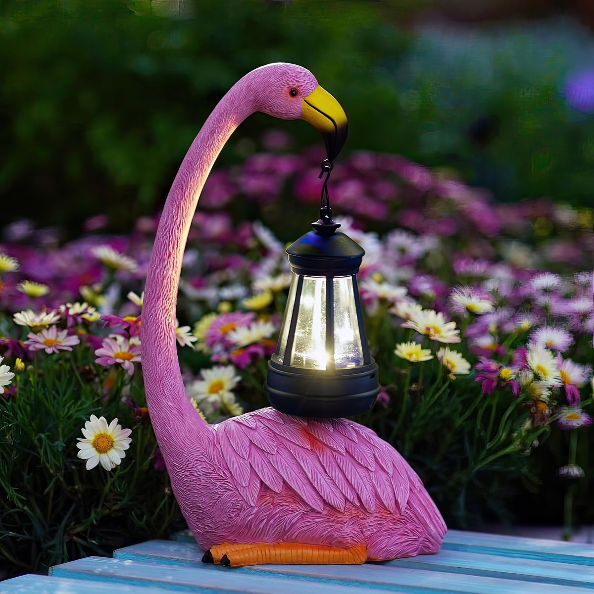 Pink flamingo-shaped solar light with a glowing lantern on a garden bench