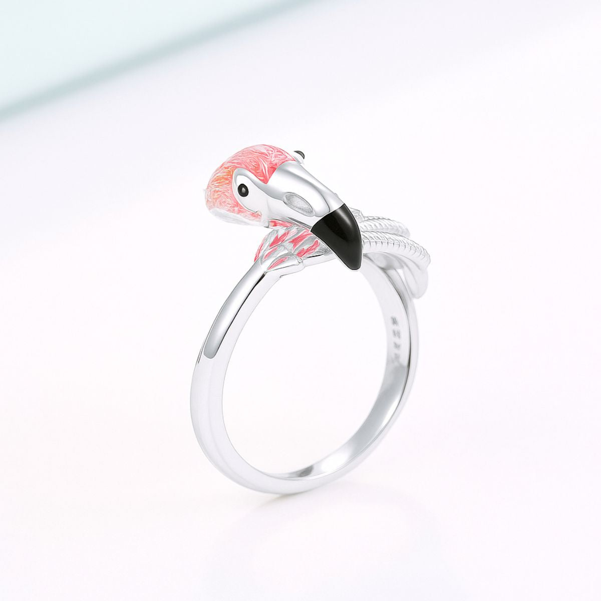 Silver ring with flamingo design on a white background