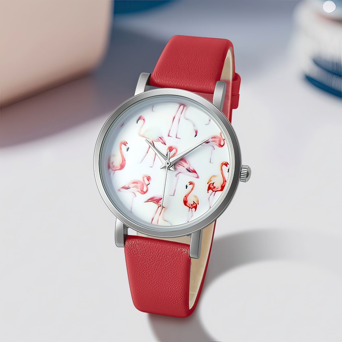 Watch with red strap and flamingo design on a light background