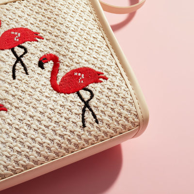 Woven bag with embroidered flamingo design on a pink background