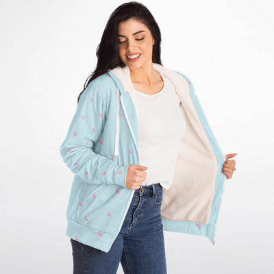 Woman wearing a light blue cardigan with a white shirt and jeans on a white background